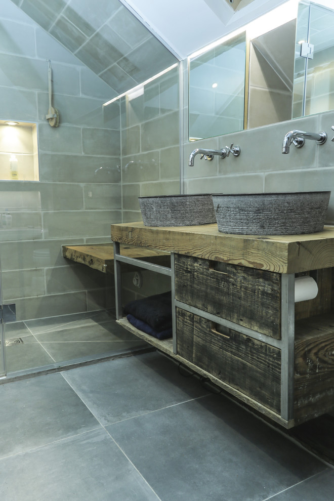 Example of a mid-sized trendy master bathroom design in London with distressed cabinets and wood countertops