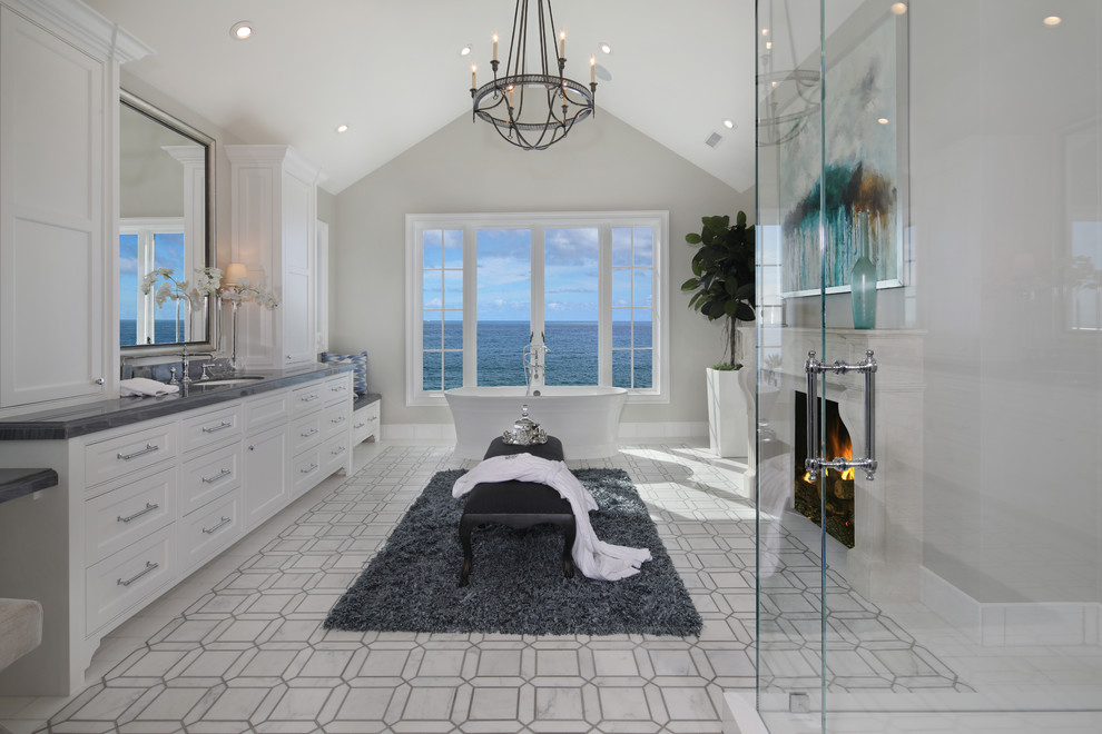 Example of a beach style master freestanding bathtub design in Orange County with shaker cabinets, white cabinets, gray walls and an undermount sink