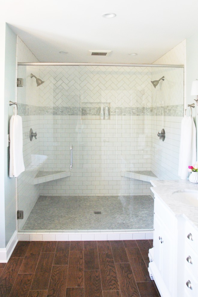 Klassisk inredning av ett mellanstort en-suite badrum, med luckor med upphöjd panel, vita skåp, ett fristående badkar, en dubbeldusch, en toalettstol med hel cisternkåpa, grå kakel, keramikplattor, blå väggar, klinkergolv i keramik, ett undermonterad handfat och marmorbänkskiva