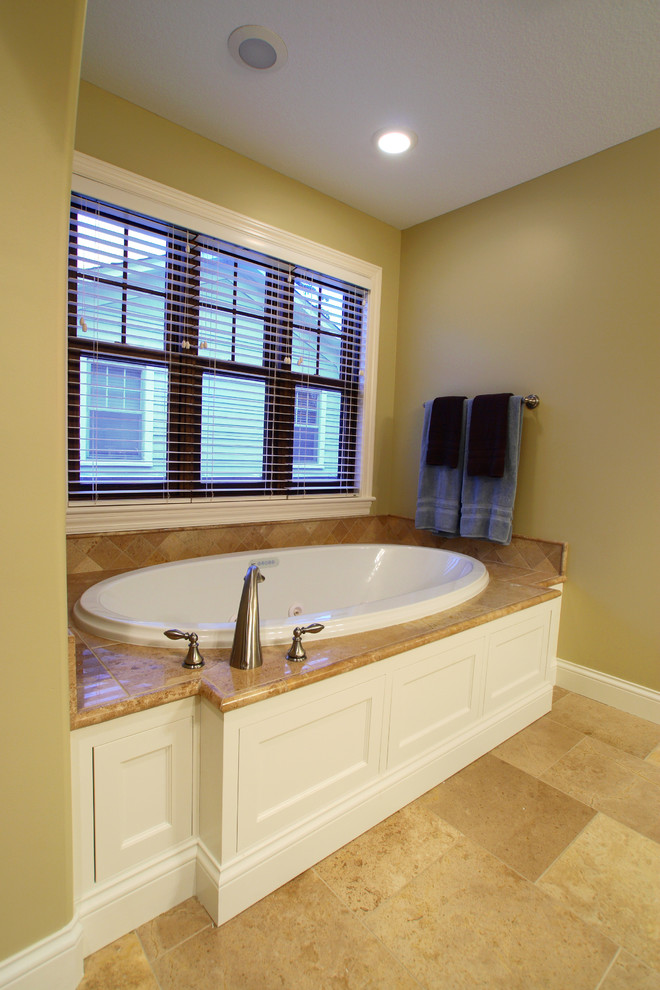 Drop-in bathtub - large craftsman master beige tile and stone tile limestone floor drop-in bathtub idea in Minneapolis with flat-panel cabinets, white cabinets, limestone countertops and beige walls