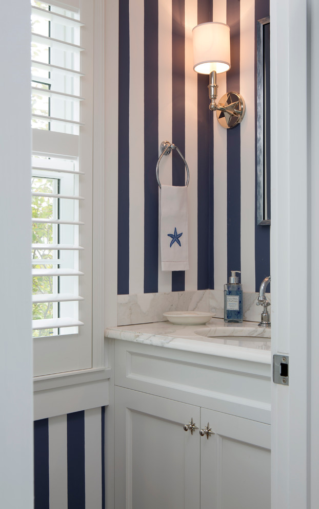 Ispirazione per una piccola stanza da bagno con doccia classica con ante con riquadro incassato, ante bianche, pareti blu, lavabo sottopiano e top in marmo