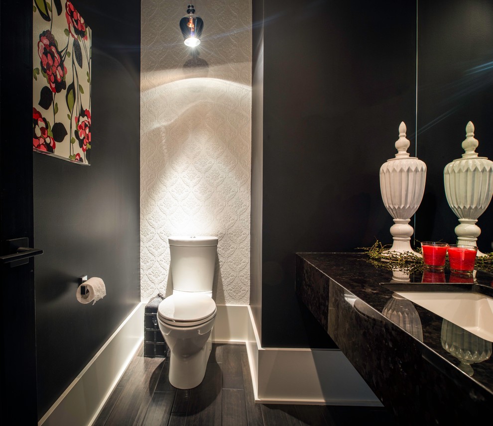 バンクーバーにある中くらいなおしゃれなトイレ・洗面所 (分離型トイレ、黒い壁、濃色無垢フローリング、アンダーカウンター洗面器、御影石の洗面台) の写真
