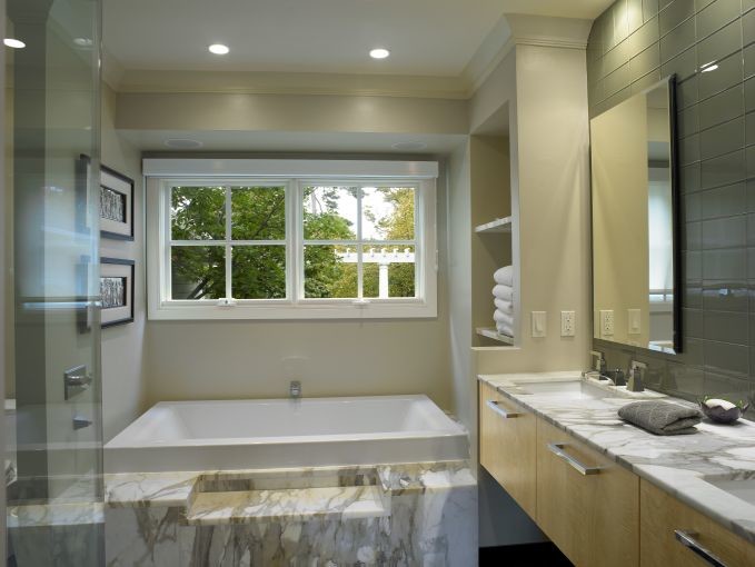 Идея дизайна: главная ванная комната среднего размера в современном стиле с плоскими фасадами, светлыми деревянными фасадами, накладной ванной, угловым душем, стеклянной плиткой, бежевыми стенами, врезной раковиной и столешницей из гранита