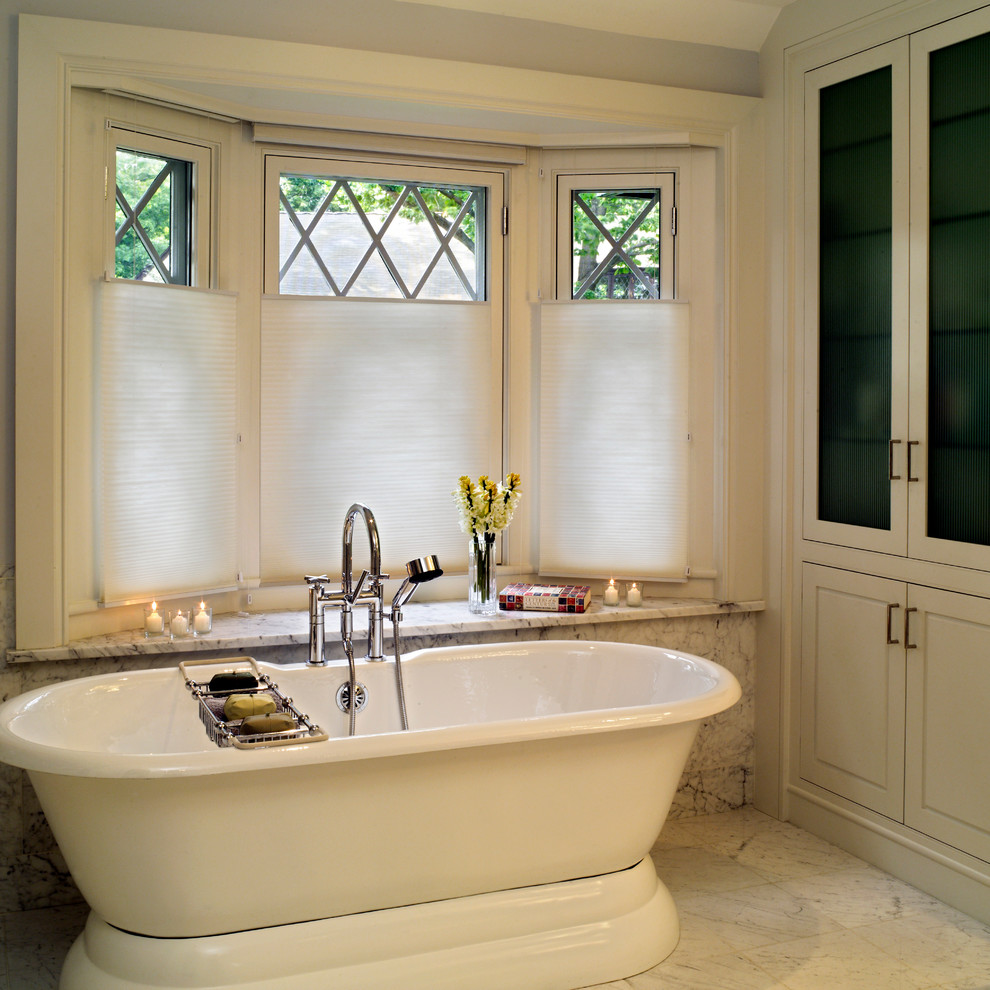 Example of a large classic master marble floor freestanding bathtub design in Boston with recessed-panel cabinets, white cabinets and white walls