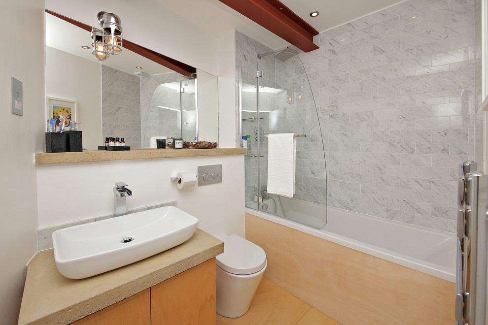 Photo of a modern bathroom in London with a corner bath and a one-piece toilet.