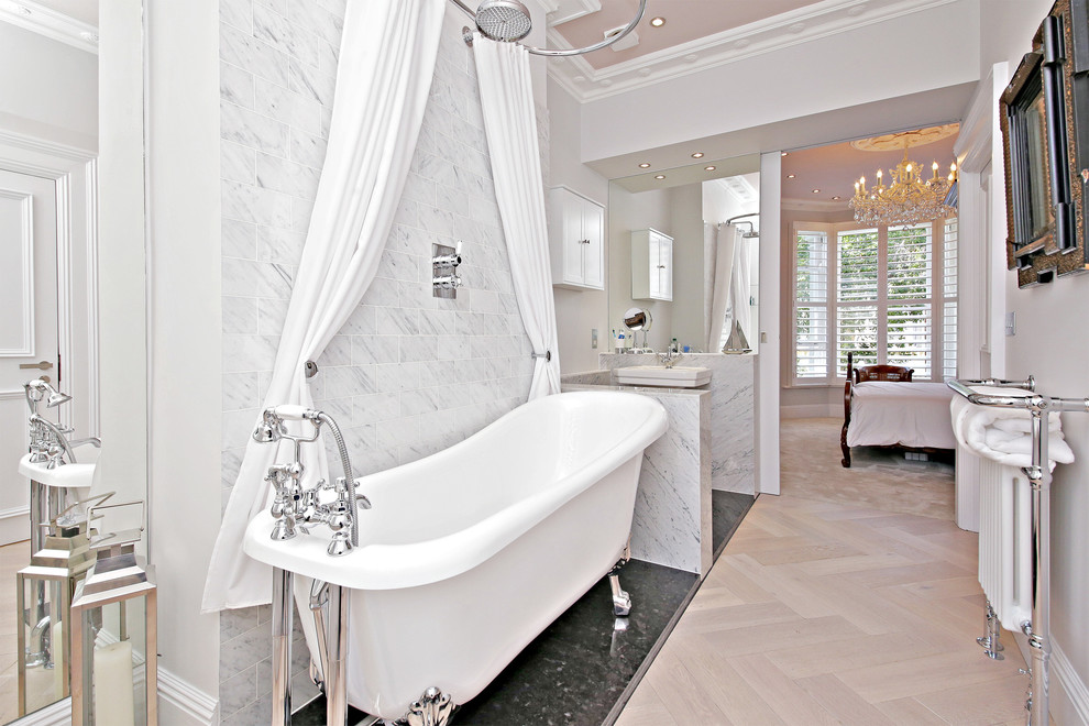 Immagine di una stanza da bagno classica con vasca con piedi a zampa di leone, pareti grigie, parquet chiaro, lavabo a colonna e doccia con tenda