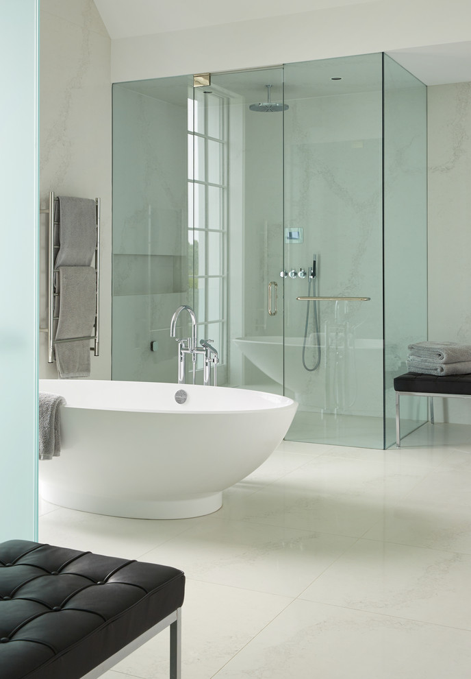 Idée de décoration pour une grande salle de bain principale design avec une baignoire indépendante, une cabine de douche à porte battante, une douche à l'italienne, un carrelage blanc, des dalles de pierre et un sol blanc.