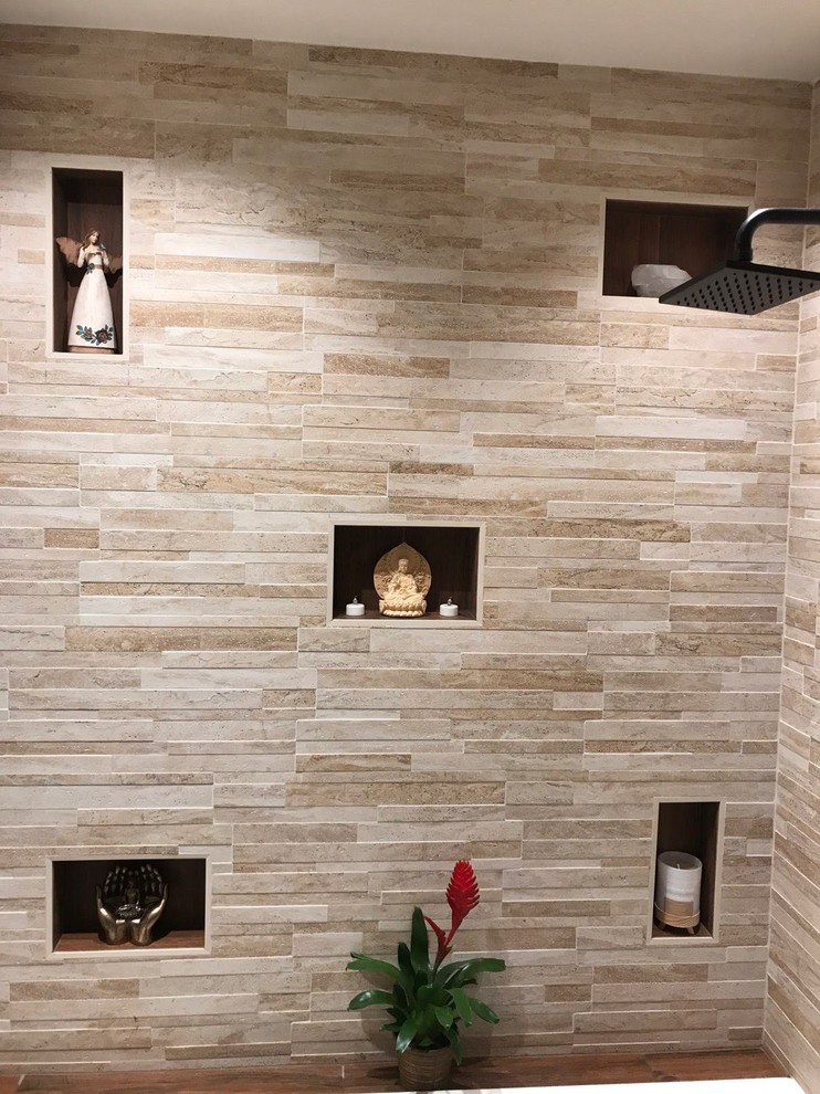 Cette image montre une petite salle de bain minimaliste avec des portes de placard marrons, une baignoire posée, WC à poser, un carrelage beige, des carreaux de porcelaine, un mur beige, un sol en carrelage de porcelaine, un lavabo encastré, un plan de toilette en marbre, un sol marron, une cabine de douche à porte battante et un plan de toilette blanc.