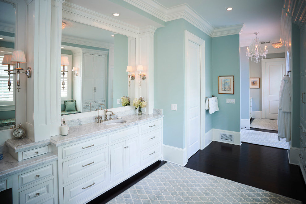 Ispirazione per un'ampia stanza da bagno padronale contemporanea con ante con riquadro incassato, ante bianche, doccia doppia, WC monopezzo, pareti blu, parquet scuro, lavabo da incasso e top in marmo