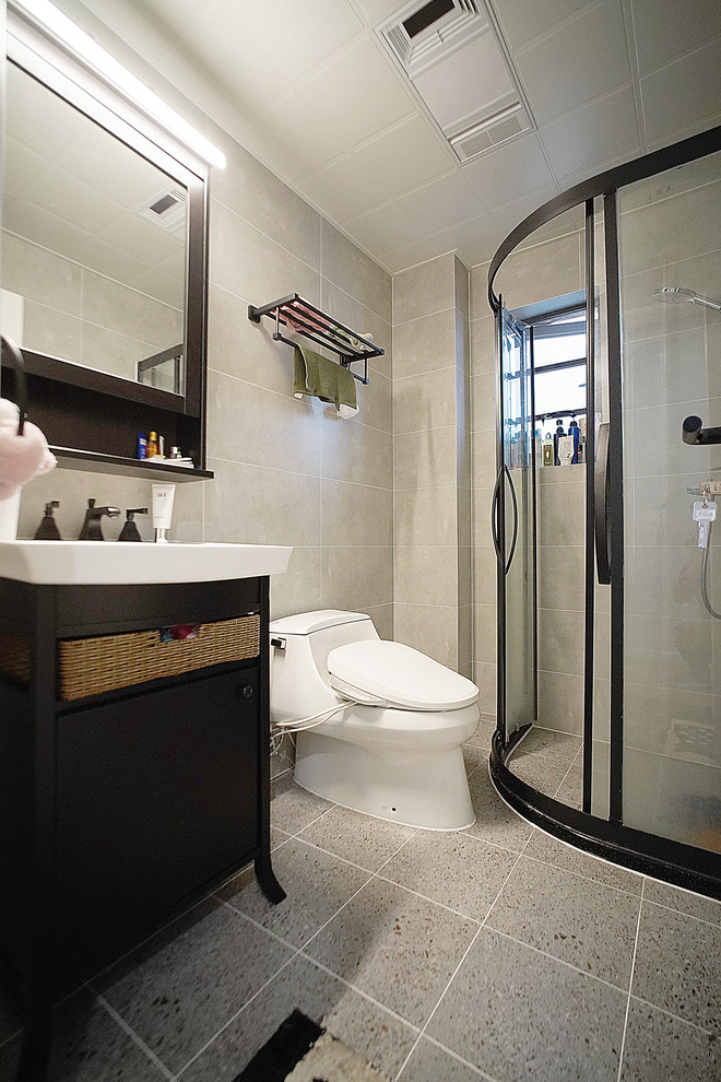 Exempel på ett litet nordiskt vit vitt badrum med dusch, med möbel-liknande, svarta skåp, ett hörnbadkar, våtrum, en toalettstol med hel cisternkåpa, grå kakel, stenkakel, grå väggar, terrazzogolv, ett fristående handfat, kaklad bänkskiva, grått golv och dusch med skjutdörr
