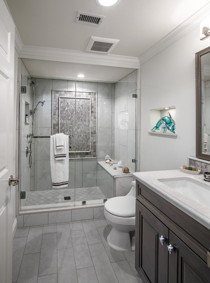 Photo of a small classic shower room bathroom in Orange County with raised-panel cabinets, grey cabinets, an alcove shower, a one-piece toilet, black and white tiles, porcelain tiles, green walls, porcelain flooring, a submerged sink, engineered stone worktops, grey floors and a hinged door.