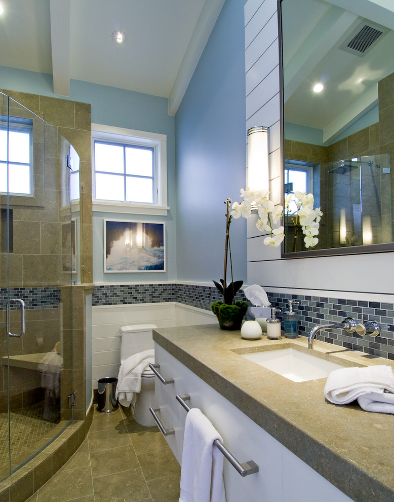 Diseño de cuarto de baño costero con encimera de cemento y baldosas y/o azulejos de piedra caliza
