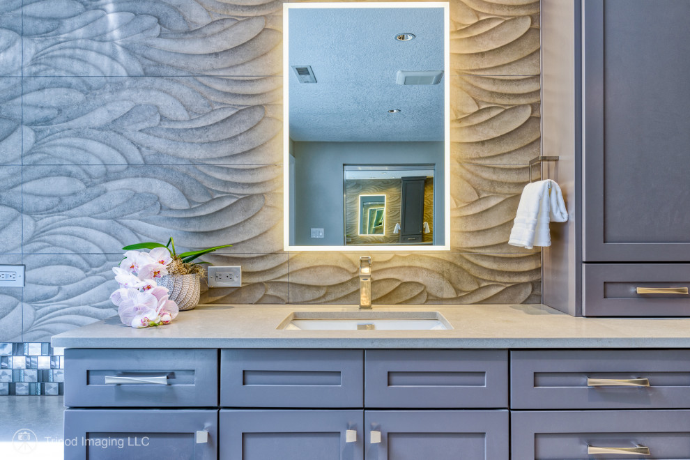 На фото: огромная главная, серо-белая ванная комната в стиле неоклассика (современная классика) с фасадами в стиле шейкер, встроенной тумбой, коричневыми фасадами, накладной ванной, угловым душем, раздельным унитазом, серой плиткой, керамогранитной плиткой, серыми стенами, полом из винила, врезной раковиной, столешницей из кварцита, серым полом, душем с распашными дверями, серой столешницей, фартуком, тумбой под две раковины, любым потолком и любой отделкой стен с