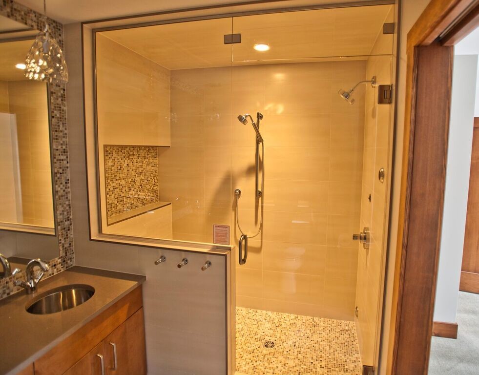 Medium sized traditional ensuite bathroom in Vancouver with flat-panel cabinets, dark wood cabinets, an alcove shower, beige tiles, grey tiles, porcelain tiles, grey walls, a submerged sink, engineered stone worktops, a hinged door, porcelain flooring and grey floors.