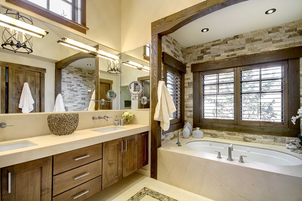 Foto de cuarto de baño rústico con bañera empotrada y piedra