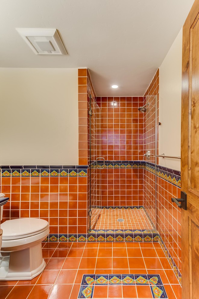 Inspiration for a medium sized shower room bathroom in Denver with a vessel sink, a claw-foot bath, a two-piece toilet, multi-coloured tiles, blue walls, mosaic tile flooring, open cabinets and medium wood cabinets.