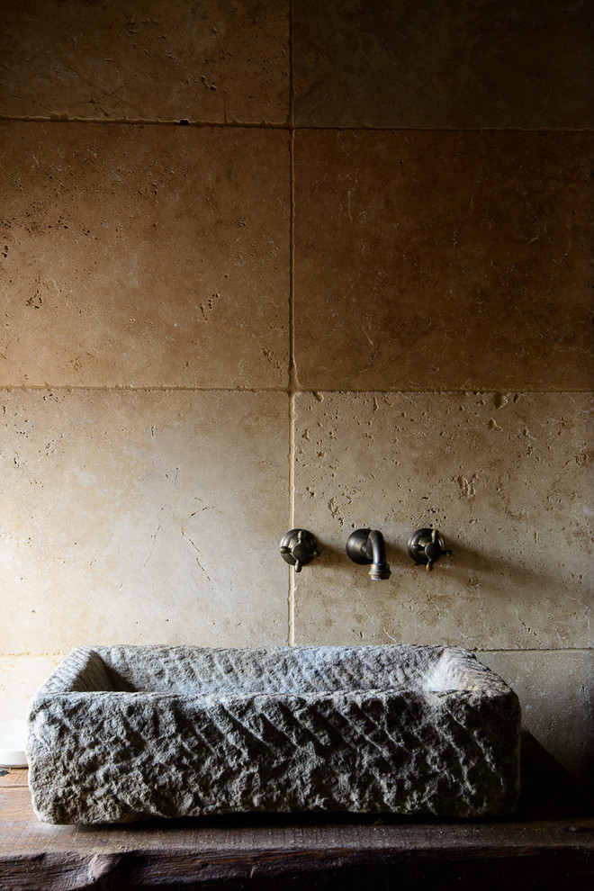 Exemple d'une petite salle de bain principale montagne en bois brun avec des dalles de pierre, un sol en travertin, un lavabo de ferme et un plan de toilette en bois.