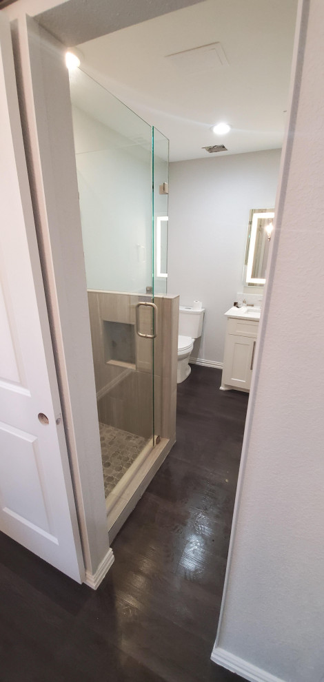 Aménagement d'une petite salle d'eau classique avec un placard avec porte à panneau encastré, des portes de placard blanches, une douche d'angle, WC séparés, un carrelage gris, un mur gris, sol en stratifié, un lavabo encastré, un plan de toilette en quartz, un sol gris, une cabine de douche à porte battante, un plan de toilette blanc, une niche, meuble simple vasque et meuble-lavabo encastré.