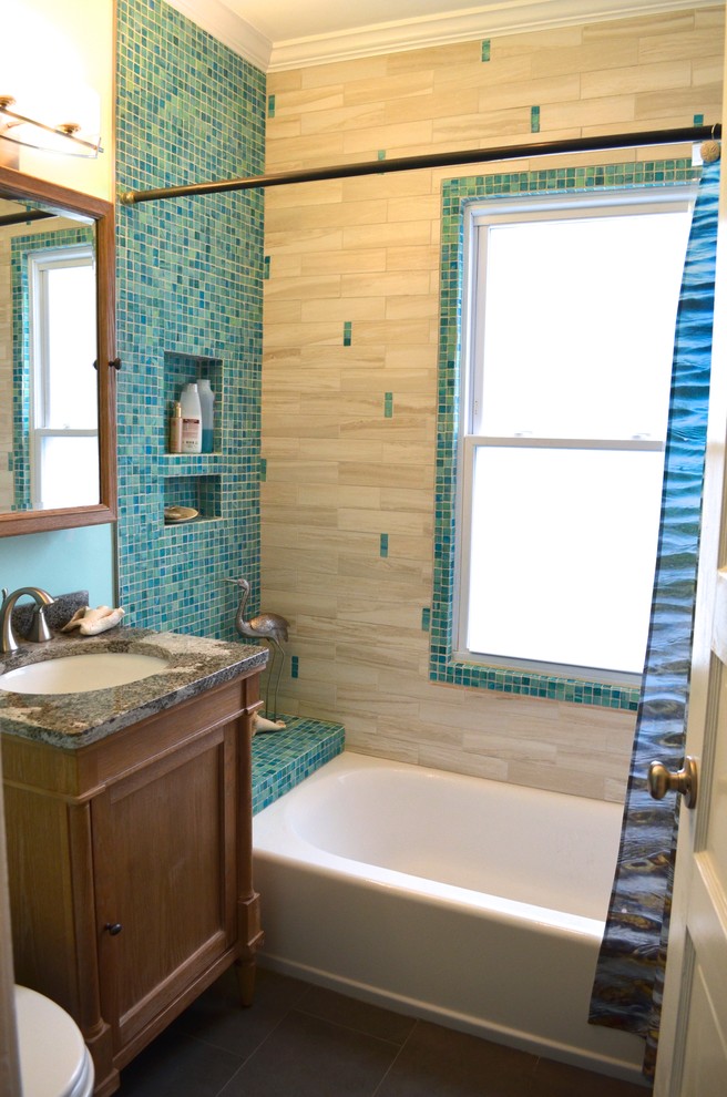 Exempel på ett litet maritimt en-suite badrum, med ett undermonterad handfat, luckor med infälld panel, skåp i mellenmörkt trä, bänkskiva i kvarts, ett badkar i en alkov, en dusch/badkar-kombination, en toalettstol med separat cisternkåpa, flerfärgad kakel, blå väggar och klinkergolv i porslin