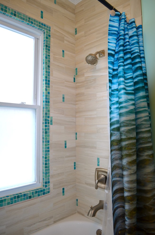 ニューヨークにある小さなビーチスタイルのおしゃれなマスターバスルーム (アンダーカウンター洗面器、落し込みパネル扉のキャビネット、中間色木目調キャビネット、クオーツストーンの洗面台、アルコーブ型浴槽、シャワー付き浴槽	、分離型トイレ、マルチカラーのタイル、青い壁、磁器タイルの床) の写真