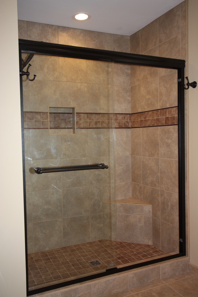Example of a classic beige tile and porcelain tile alcove shower design in Raleigh with an integrated sink, raised-panel cabinets, medium tone wood cabinets, solid surface countertops and a two-piece toilet