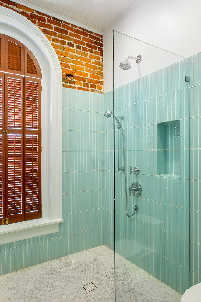 Immagine di una stanza da bagno industriale con doccia a filo pavimento, piastrelle blu, piastrelle di vetro, pavimento in marmo e doccia aperta
