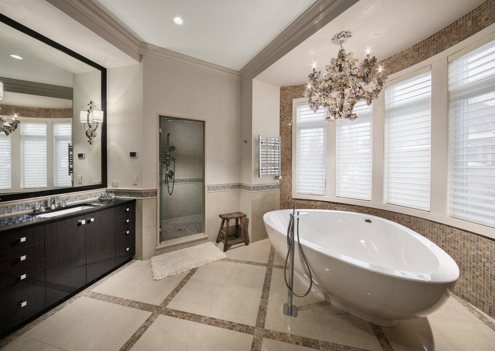 Inredning av ett klassiskt badrum, med ett undermonterad handfat, släta luckor, ett fristående badkar, en dusch i en alkov, beige kakel och beige väggar