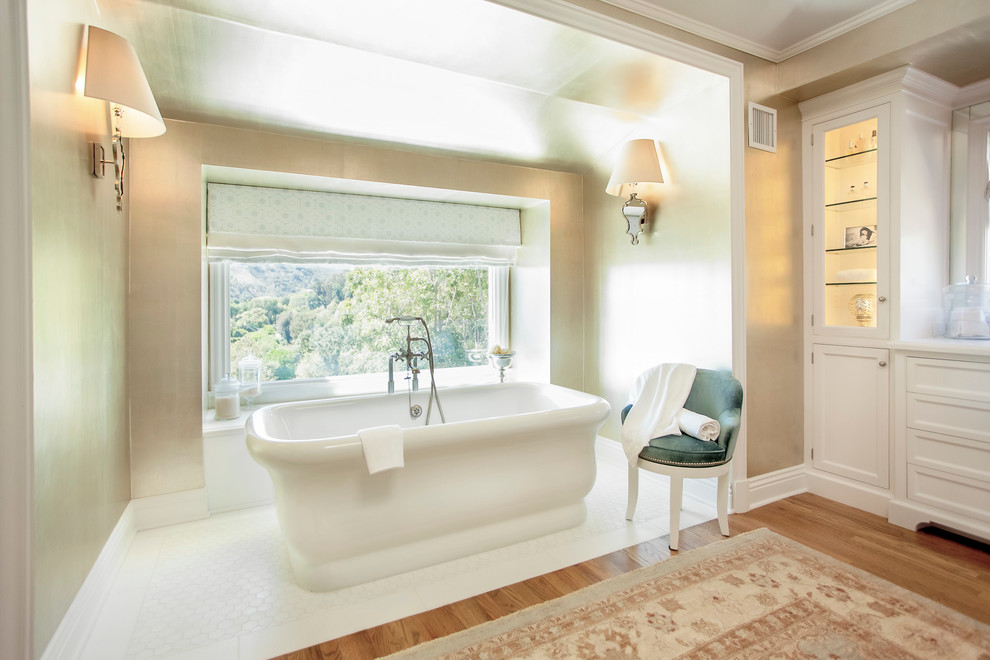 На фото: ванная комната в стиле неоклассика (современная классика) с фасадами с утопленной филенкой, белыми фасадами и отдельно стоящей ванной с