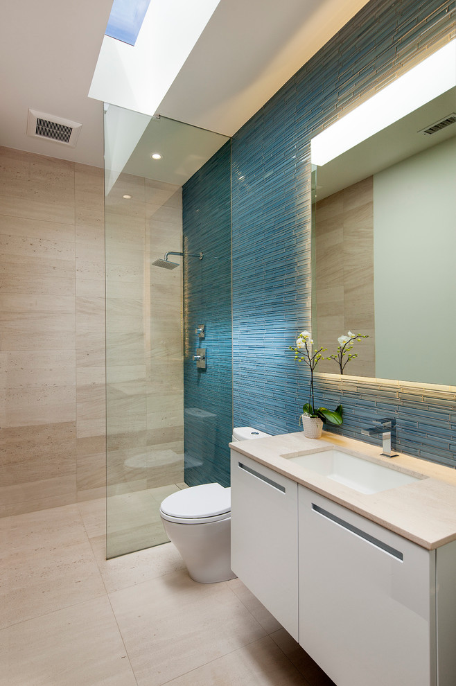 Ispirazione per una stanza da bagno design con ante lisce, ante bianche, doccia aperta, piastrelle blu, piastrelle a listelli, lavabo sottopiano e doccia aperta