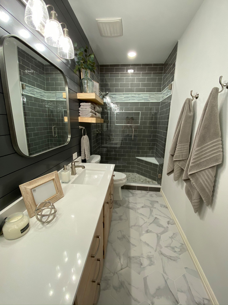 Bild på ett litet lantligt vit vitt badrum med dusch, med luckor med upphöjd panel, skåp i ljust trä, en dusch i en alkov, grå kakel, tunnelbanekakel, grå väggar, klinkergolv i porslin, ett undermonterad handfat, bänkskiva i kvarts, grått golv och dusch med gångjärnsdörr