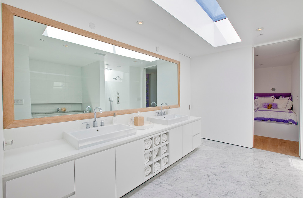 Modelo de cuarto de baño moderno con lavabo sobreencimera, armarios con paneles lisos, puertas de armario blancas y baldosas y/o azulejos grises