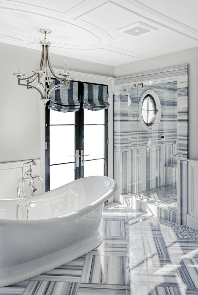 Modelo de cuarto de baño clásico renovado con bañera exenta, ducha empotrada y baldosas y/o azulejos de piedra