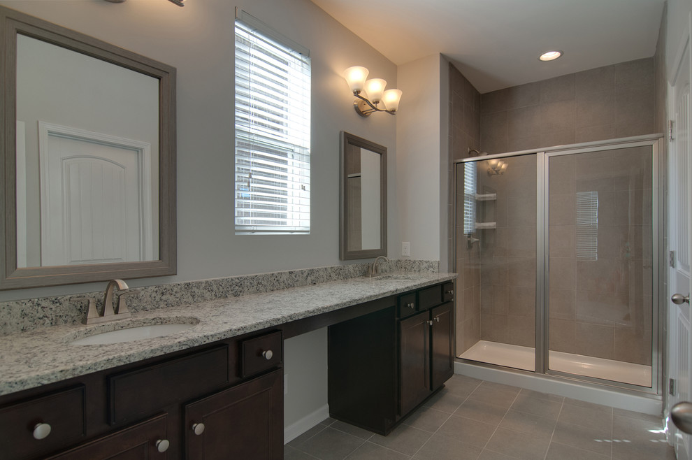 Design ideas for a medium sized classic ensuite bathroom in Nashville with a submerged sink, recessed-panel cabinets, dark wood cabinets, granite worktops, a corner shower, a two-piece toilet, grey tiles, ceramic tiles, grey walls and ceramic flooring.
