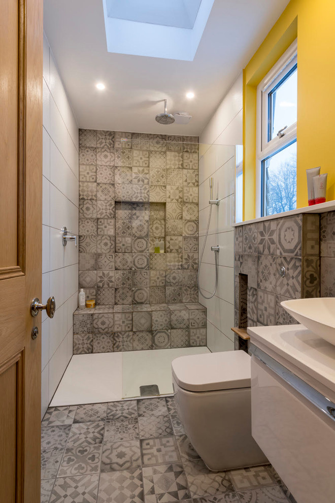 Idéer för att renovera ett mellanstort eklektiskt vit vitt badrum med dusch, med släta luckor, vita skåp, en kantlös dusch, en toalettstol med hel cisternkåpa, grå kakel, vita väggar, ett fristående handfat, grått golv och med dusch som är öppen
