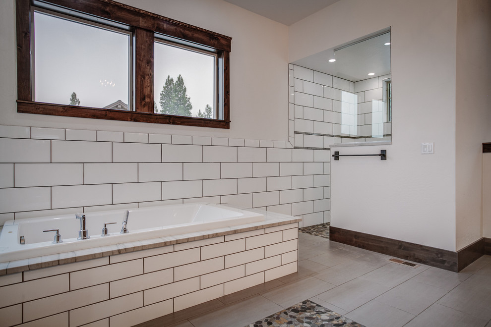 Cette image montre une grande salle de bain principale chalet avec une baignoire posée, une douche ouverte, un carrelage blanc, un carrelage métro, un mur blanc et un sol en carrelage de céramique.
