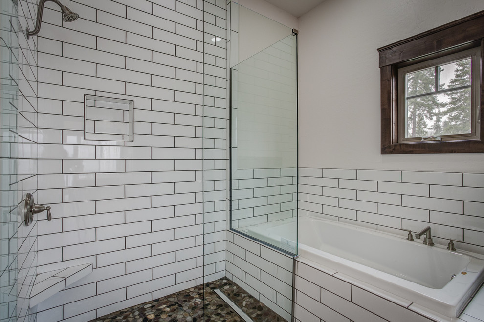 Rustik inredning av ett mellanstort badrum, med ett platsbyggt badkar, en hörndusch, vit kakel, tunnelbanekakel, vita väggar och klinkergolv i småsten