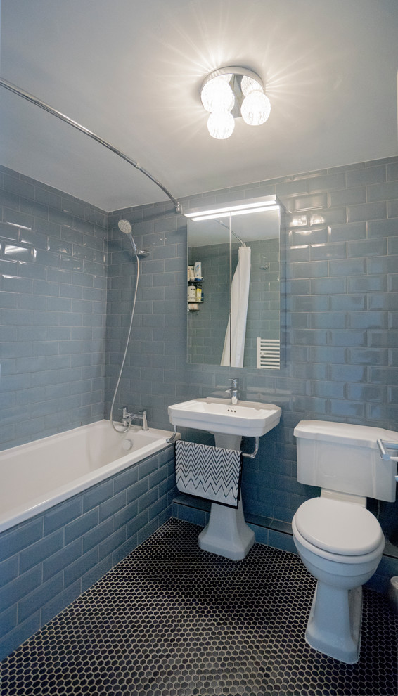Exemple d'une salle de bain tendance de taille moyenne pour enfant avec une baignoire posée, un combiné douche/baignoire, WC séparés, un carrelage bleu, un carrelage métro, un mur bleu, un sol en carrelage de terre cuite, un lavabo de ferme, un sol noir et une cabine de douche avec un rideau.