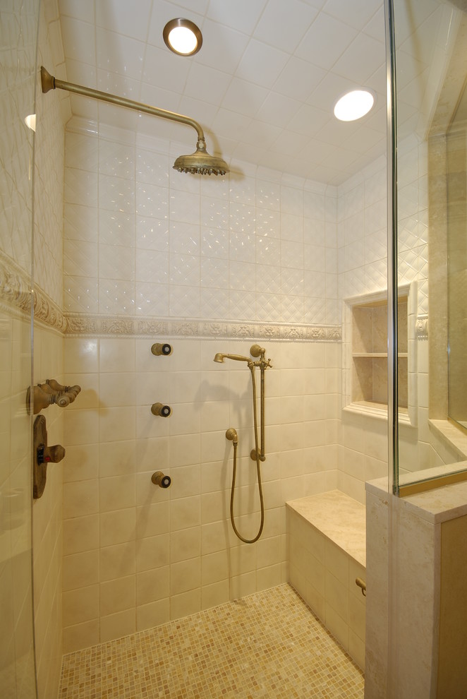 Пример оригинального дизайна: баня и сауна среднего размера в средиземноморском стиле с бежевой плиткой, керамогранитной плиткой, врезной раковиной, фасадами с выступающей филенкой, темными деревянными фасадами, столешницей из известняка, отдельно стоящей ванной, желтыми стенами, полом из мозаичной плитки и душем в нише