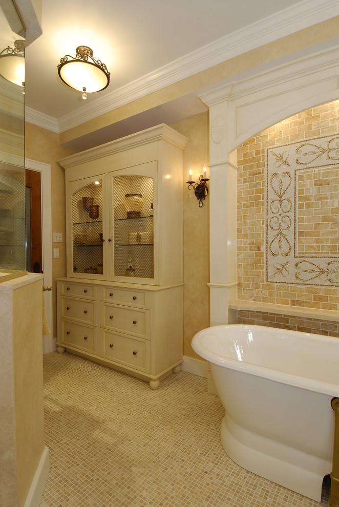 Свежая идея для дизайна: баня и сауна среднего размера в средиземноморском стиле с врезной раковиной, фасадами с выступающей филенкой, темными деревянными фасадами, столешницей из известняка, отдельно стоящей ванной, бежевой плиткой, керамогранитной плиткой, желтыми стенами и полом из мозаичной плитки - отличное фото интерьера