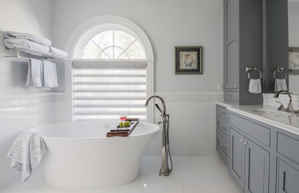 Freestanding bathtub - traditional white tile white floor freestanding bathtub idea in Boston with gray cabinets, gray walls, an undermount sink, white countertops and beaded inset cabinets
