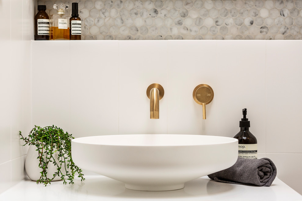 Inspiration for a medium sized contemporary ensuite bathroom in Melbourne with flat-panel cabinets, light wood cabinets, a freestanding bath, a walk-in shower, a one-piece toilet, white tiles, mosaic tiles, white walls, porcelain flooring, a console sink, engineered stone worktops, grey floors, an open shower and white worktops.