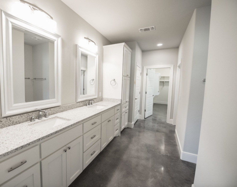На фото: большая главная ванная комната в стиле кантри с фасадами в стиле шейкер, белыми фасадами, душем в нише, серыми стенами, бетонным полом, врезной раковиной и столешницей из гранита