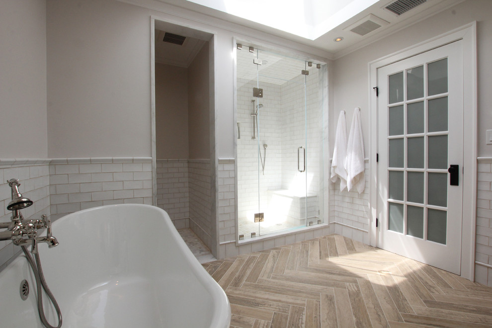 На фото: большая главная ванная комната в классическом стиле с плоскими фасадами, светлыми деревянными фасадами, отдельно стоящей ванной, душем в нише, белой плиткой, плиткой кабанчик, белыми стенами, полом из травертина, врезной раковиной и мраморной столешницей с