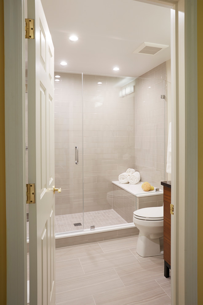 Aménagement d'une salle de bain contemporaine en bois foncé de taille moyenne avec un placard à porte plane, WC à poser, un carrelage beige, un carrelage métro, un mur beige, un sol en carrelage de porcelaine, un lavabo encastré et un plan de toilette en surface solide.