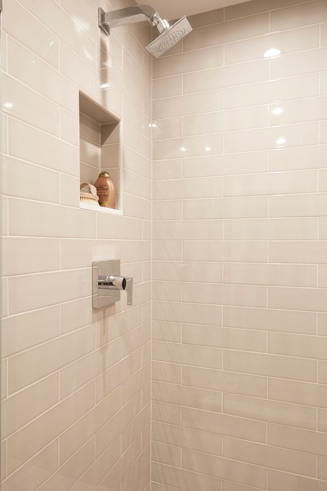 Exemple d'une salle de bain tendance en bois foncé de taille moyenne avec un placard à porte plane, WC à poser, un carrelage beige, un carrelage métro, un mur beige, un sol en carrelage de porcelaine, un lavabo encastré et un plan de toilette en surface solide.