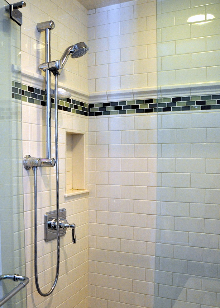 Inredning av ett klassiskt litet badrum med dusch, med ett undermonterad handfat, möbel-liknande, bänkskiva i kvarts, vit kakel, skåp i mörkt trä, en dusch i en alkov, en toalettstol med separat cisternkåpa, tunnelbanekakel, gröna väggar och travertin golv