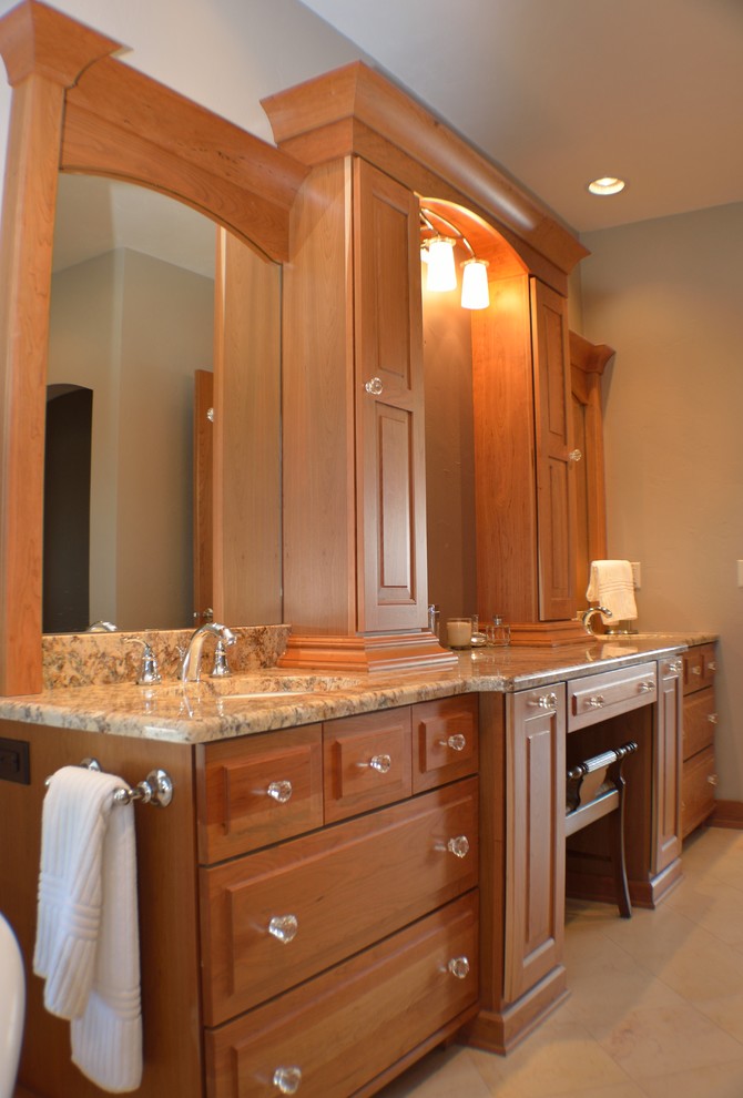 Imagen de cuarto de baño principal clásico grande con armarios con paneles con relieve, puertas de armario de madera oscura, encimera de granito, baldosas y/o azulejos beige y suelo de travertino