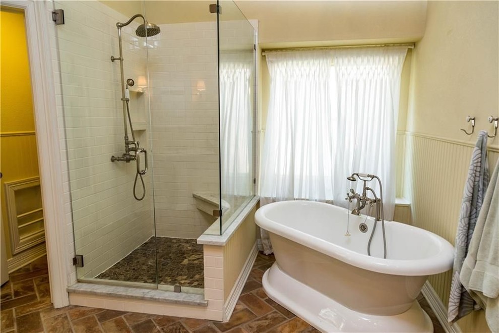 ダラスにある中くらいなラスティックスタイルのおしゃれなマスターバスルーム (コーナー設置型シャワー、分離型トイレ、ベージュの壁、レンガの床、開き戸のシャワー、置き型浴槽、白いタイル、サブウェイタイル、茶色い床) の写真