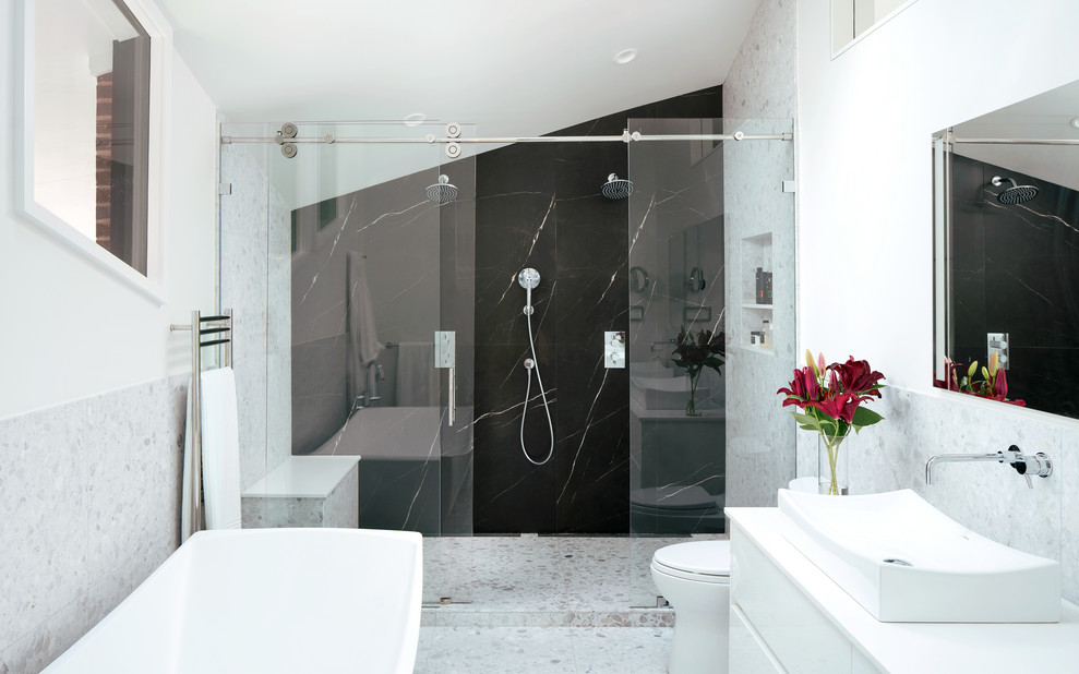 Inspiration for a modern ensuite bathroom in Denver with flat-panel cabinets, white cabinets, a freestanding bath, a double shower, a one-piece toilet, marble tiles, white walls, terrazzo flooring, a vessel sink, engineered stone worktops, white floors, a sliding door and white worktops.