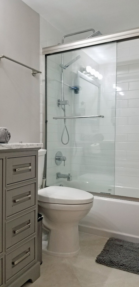 Exempel på ett mellanstort modernt en-suite badrum, med skåp i shakerstil, grå skåp, ett platsbyggt badkar, en dusch/badkar-kombination, en toalettstol med hel cisternkåpa, vit kakel, grå väggar, klinkergolv i keramik, ett integrerad handfat, marmorbänkskiva, beiget golv och dusch med skjutdörr
